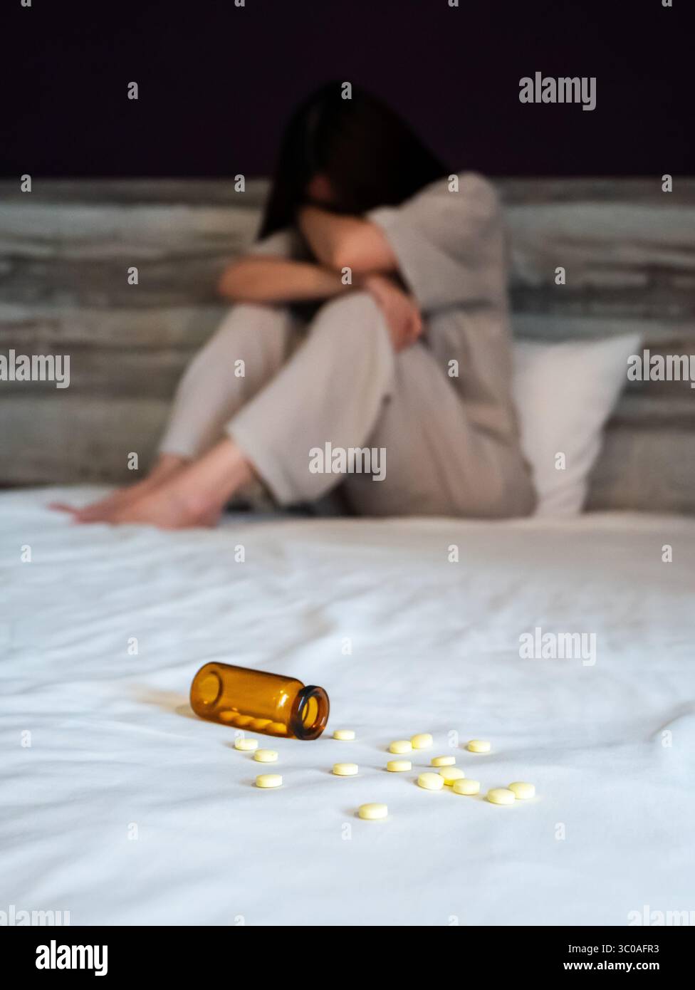 la donna soffre di insonnia, si concentra sulle sonniferi in primo piano sul letto. vista frontale dello stress femminile in camera da letto con disturbi del sonno. insonnia depressione Foto Stock