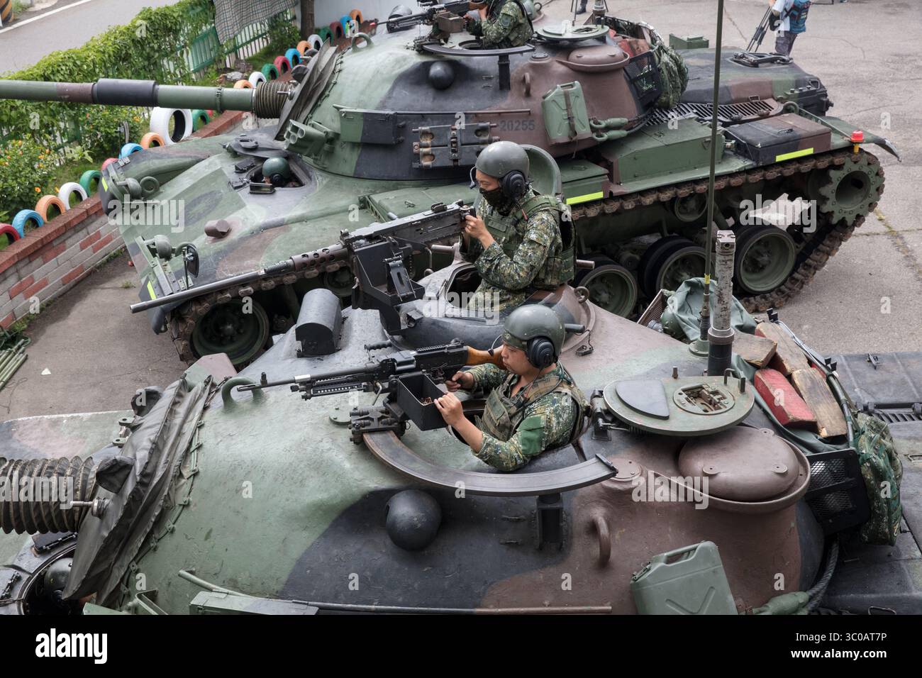 L'equipaggio dei carri armati dell'esercito tiene le mitragliatrici mentre conducono l'addestramento al combattimento durante l'esercitazione militare annuale Han Kuang di Taiwan il 16 luglio 2025 Foto Stock