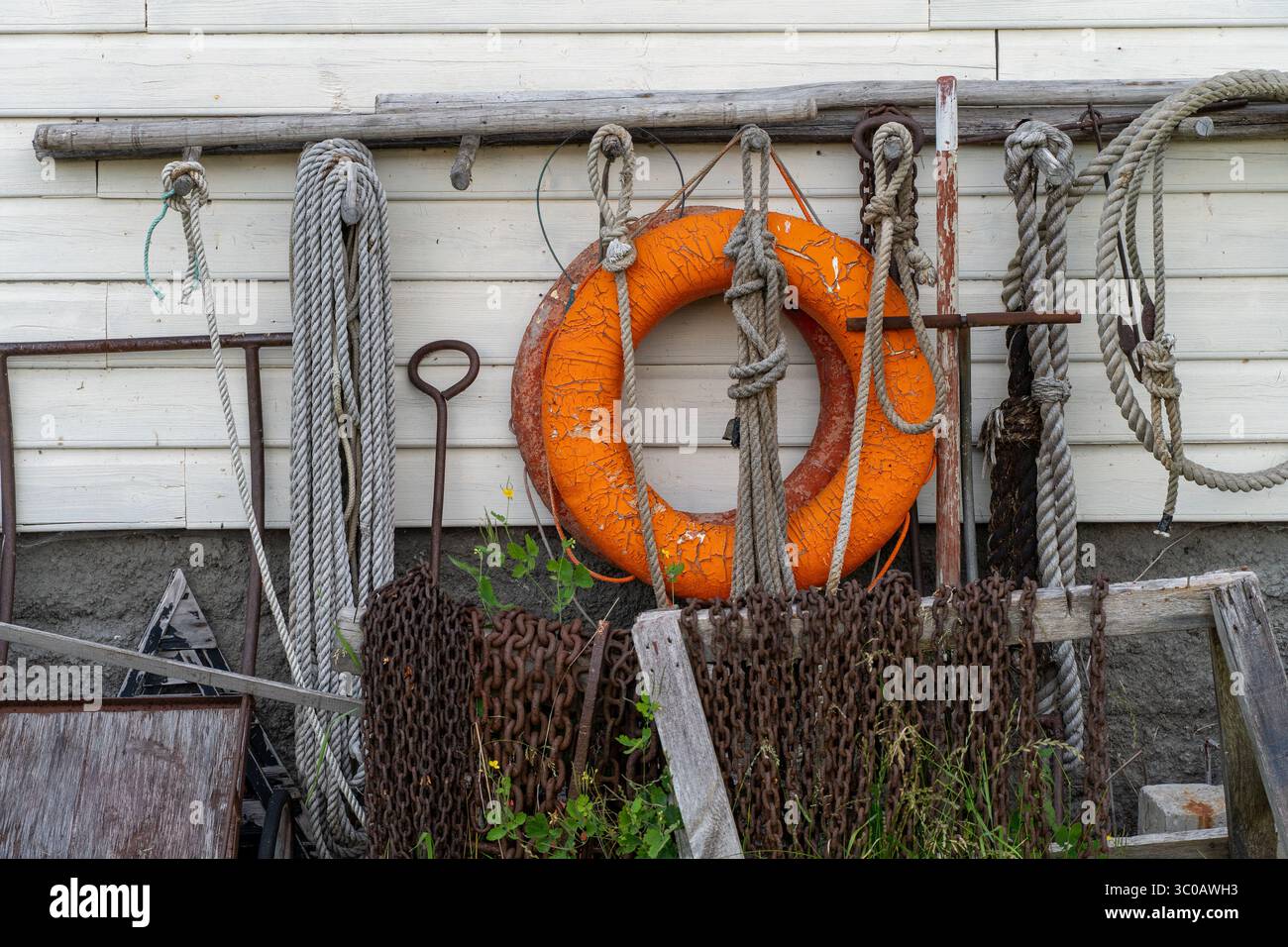 Raccolta di strumenti nautici e corde su pareti di legno bianco a Käsmu, – patrimonio marittimo, cultura costiera, salvagente, equipaggiamento di sicurezza, texture visiva Foto Stock