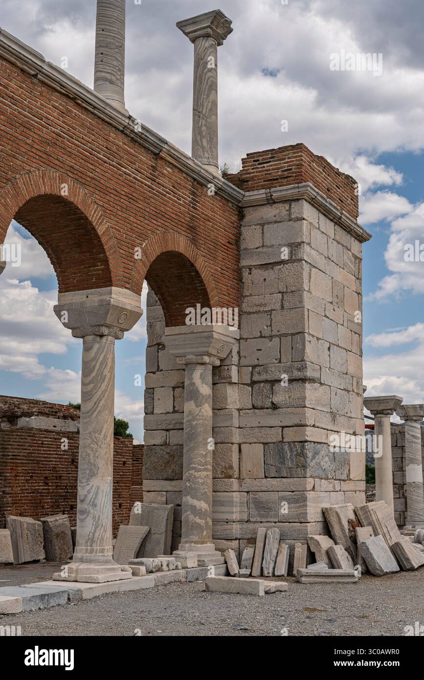Sotto le nuvole mutevoli, la luce del sole cade attraverso Selcúk, Turchia, rivelando nobili archi gemelli della Basilica di San Giovanni che sorgono in silenziosa dignità. Foto Stock