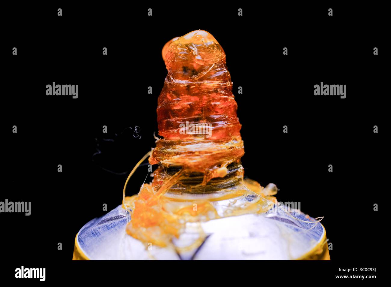 Primo piano dell'adesivo arancione essiccato su una provetta schiacciata Foto Stock