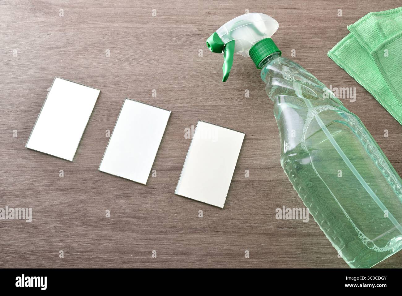 prodotto detergente per vetri in flacone spray tavolo in legno con vetro e panno per pulizia verde. Vista dall'alto. Foto Stock