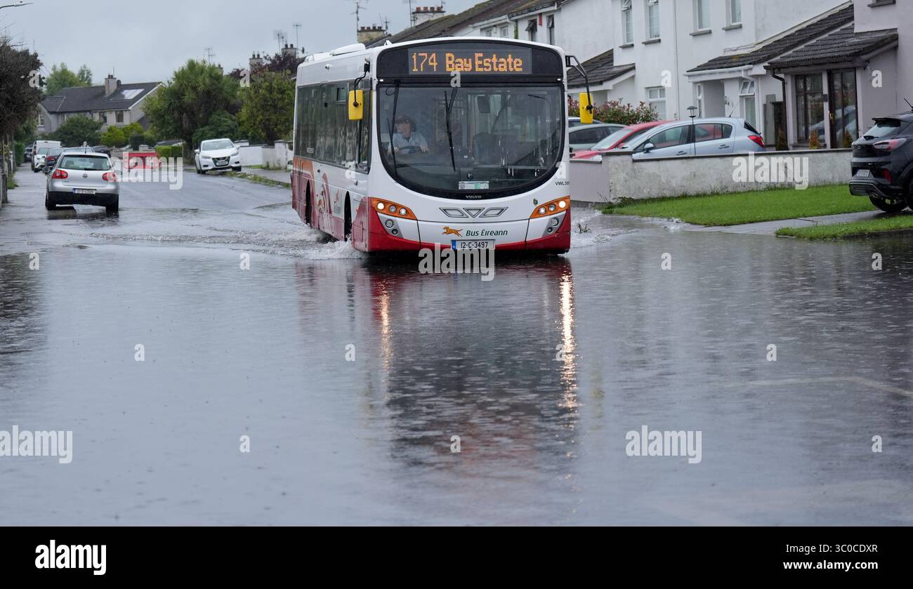Un autobus passa attraverso le acque alluvionali della Bay Estate a Dundalk, Co Louth, mentre gli avvisi meteorologici di livello arancione erano in vigore per alcune parti dell'Irlanda dopo una notte di forti piogge attraverso l'isola. Data foto: Lunedì 21 luglio 2025. Foto Stock