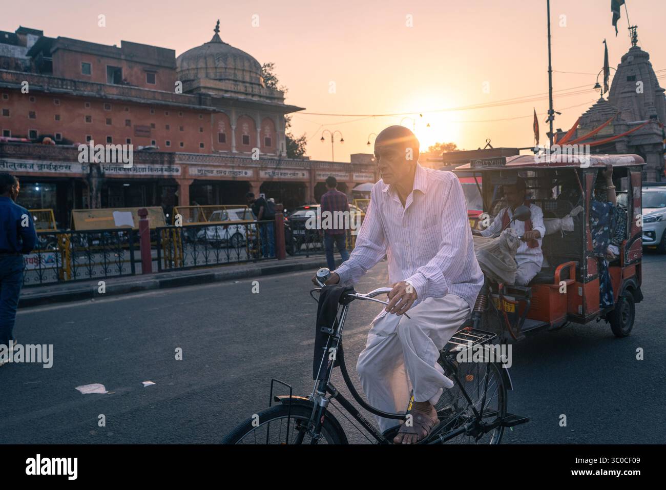 Rajasthan, Jaipur, India - un uomo al tramonto che cavalca una vecchia bicicletta arrugginita Foto Stock