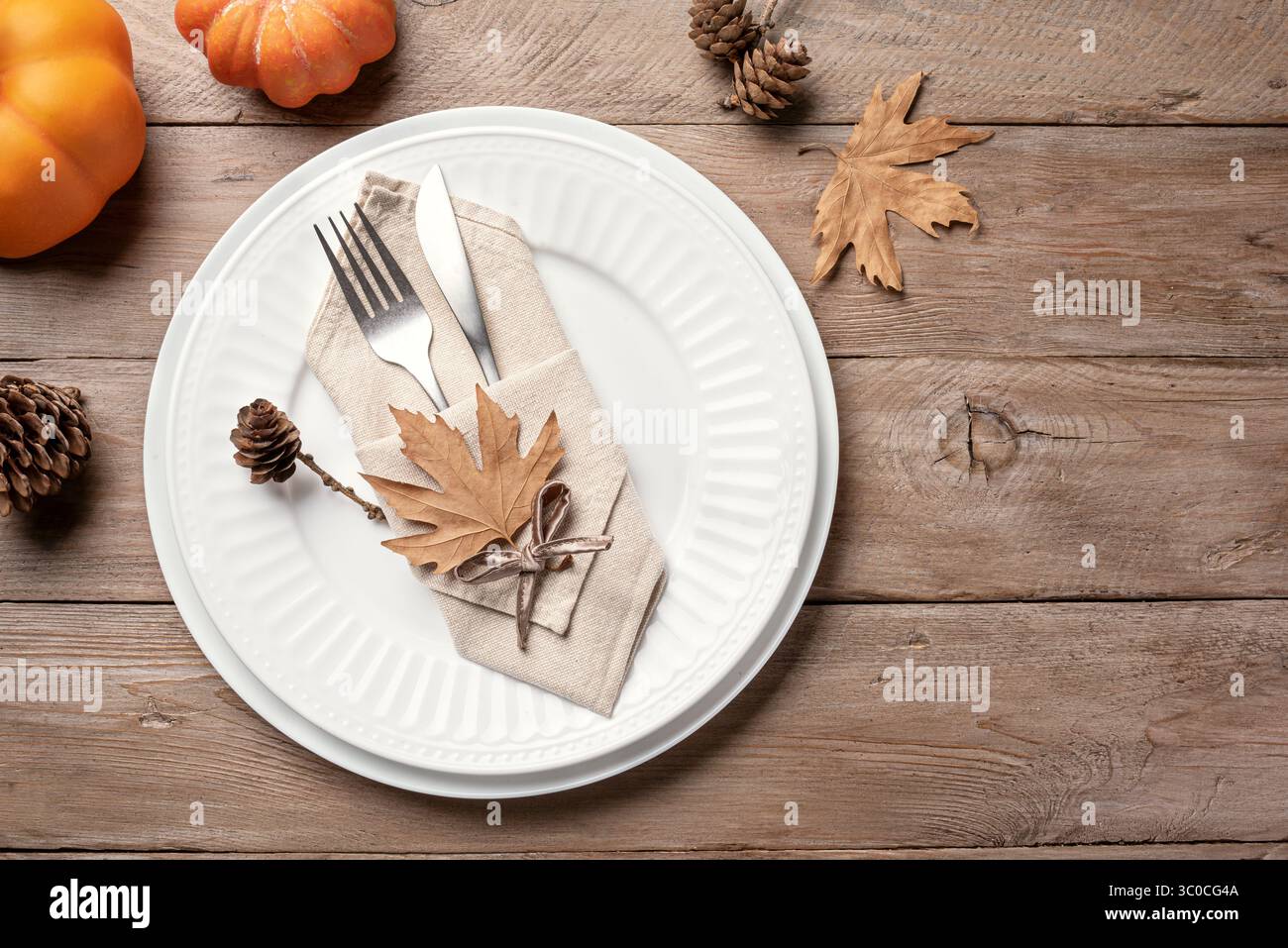 Il giorno del Ringraziamento o il luogo di Halloween con zucche e foglie d'acero asciutte su sfondo in legno, vista dall'alto, spazio per le copie. Setti da tavolo per le vacanze autunnali Foto Stock
