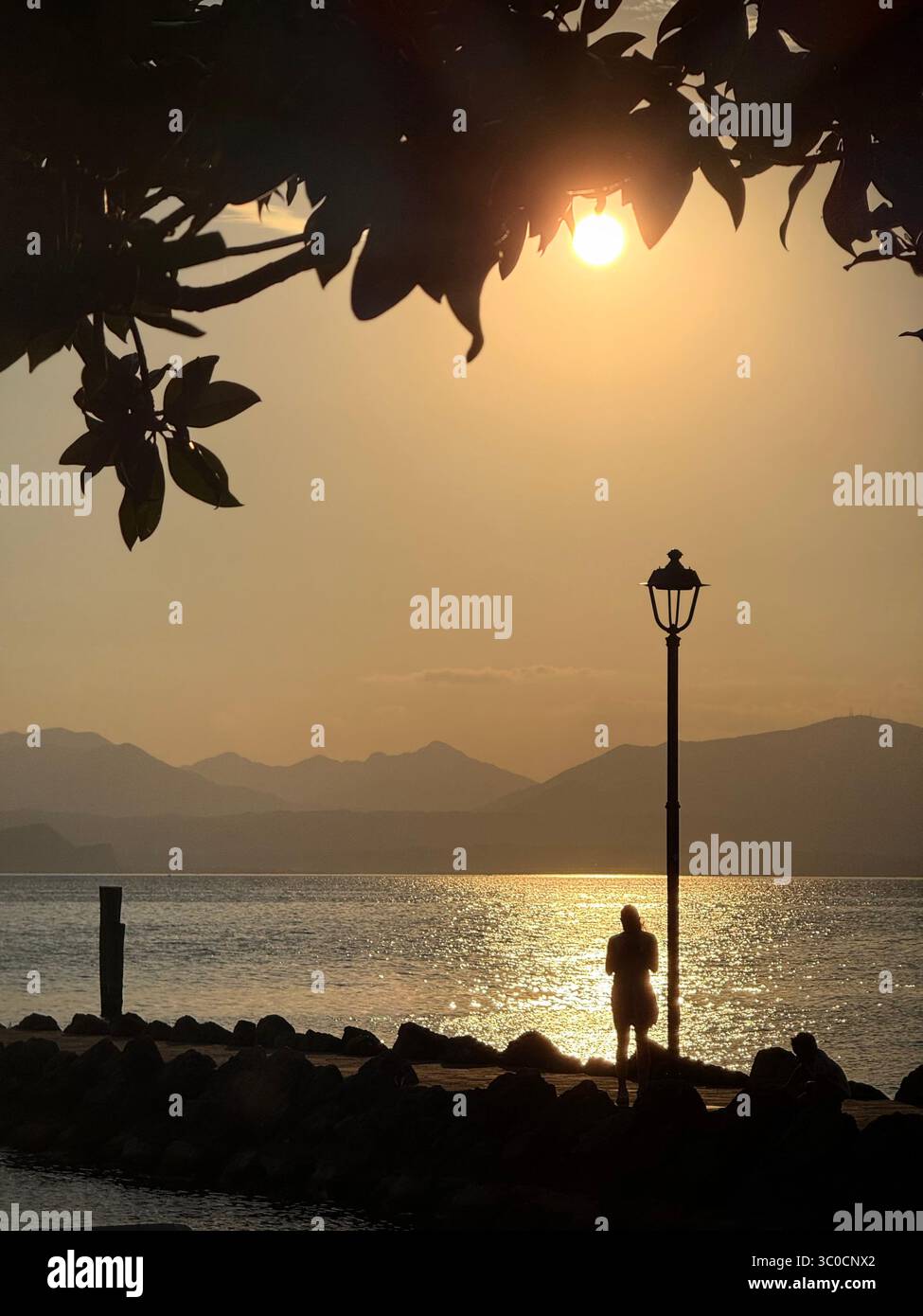 Tramonto sul molo di Cisano (vicino a Bardolino) sul Lago di Garda Foto Stock