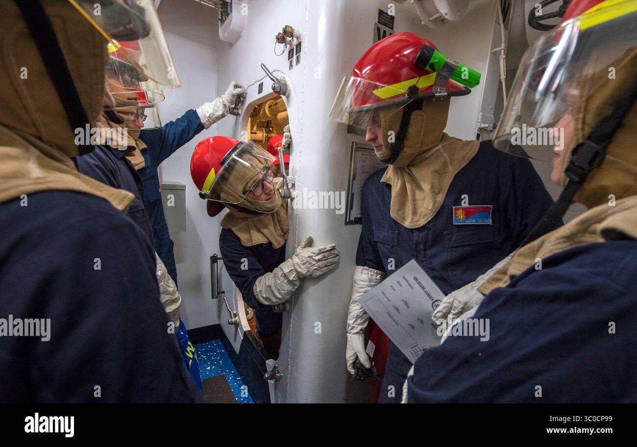 21 agosto 2018 - Mare della Cina orientale - i marinai trasmettono messaggi per un'inondazione simulata durante un'esercitazione del gruppo di addestramento per il controllo dei danni a bordo del cacciatorpediniere missilistico guidato classe Arleigh Burke USS Benfold (DDG 65). Benfold è schierato in avanti nella 7th Fleet area of Operations degli Stati Uniti a sostegno della sicurezza e della stabilità nella regione Indo-Pacifico. (Immagine di credito: © U.S. Navy/ZUMA Wire/ZUMAPRESS.com) Foto Stock