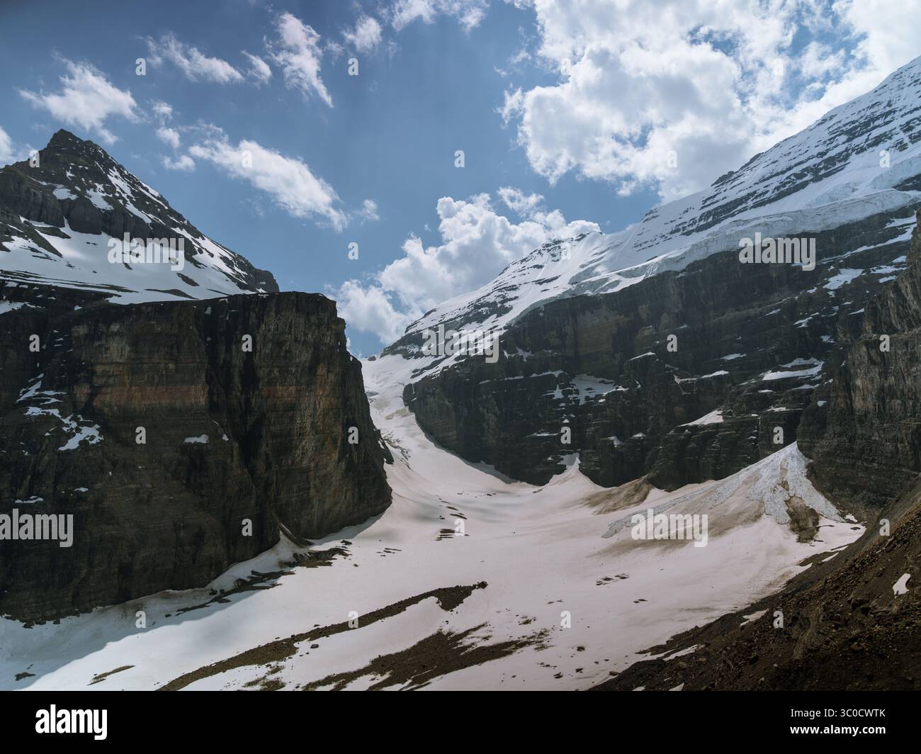 Vista della spettacolare valle del ghiacciaio tra il Monte Lefroy e il Monte Victoria nelle Montagne Rocciose canadesi, con pendii innevati e un cielo parzialmente nuvoloso. Foto Stock