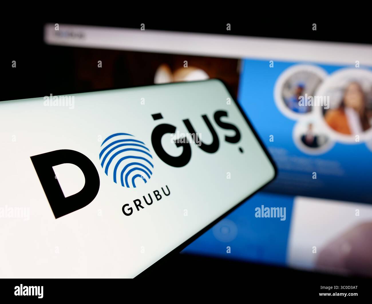 Stoccarda, Germania - 05-16-2025: Smartphone con logo della società turca Dogus Holding A.S., sullo schermo davanti al sito web. Foto Stock