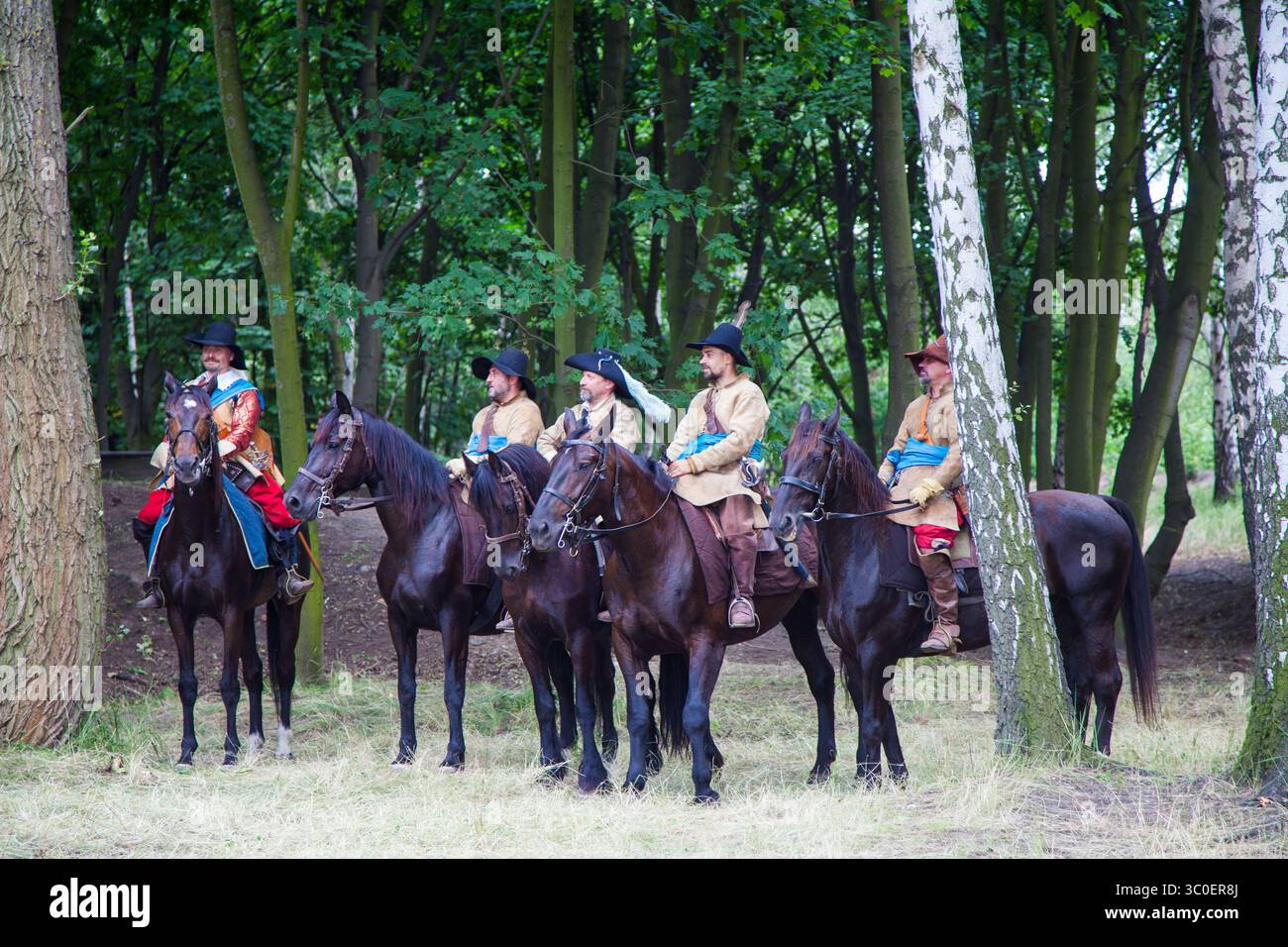 Danzica, Polonia - 06-07-2025 - i cavalieri in abbigliamento d'epoca salutano il pubblico mentre sono montati su cavalli scuri in un evento educativo di rievocazione Foto Stock