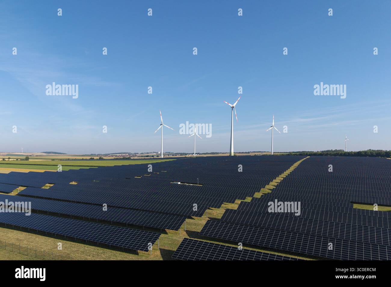 Centrali a energia rinnovabile con pannelli solari e turbine eoliche in un'area aperta, vicino a Kitzingen, bassa Franconia, Baviera, Germania Foto Stock