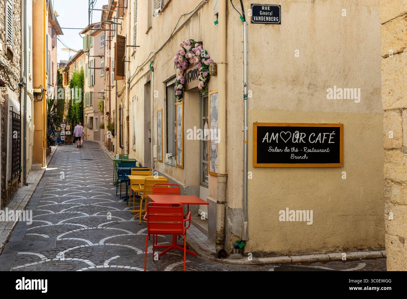 ANTIBES, Francia 8-24-2024: Affascinante Amour Café con i suoi tavoli colorati all'angolo di due stradine del centro storico Foto Stock