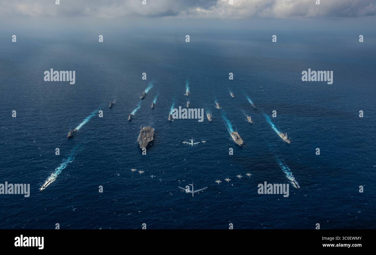8 novembre 2018 - Philippine Sea - la portaerei USS Ronald Reagan (CVN 76), a sinistra, e il cacciatorpediniere elicotteri JS Hyuga (DDH 181) della Japan Maritime Self-Defense Force, a destra, salpano in formazione con altre 16 navi della US Navy e della Japan Maritime Self-Defense Force come velivoli della US Air Force e della Japan Air Self-Defense Force volano in formazione durante la Keen Sword 2019. Keen Sword 2019 è un'esercitazione congiunta bilaterale sul campo che coinvolge militari statunitensi e personale JMSDF, progettata per aumentare la prontezza al combattimento e l'interoperabilità dell'alleanza Giappone-Stati Uniti. (Credito Foto Stock