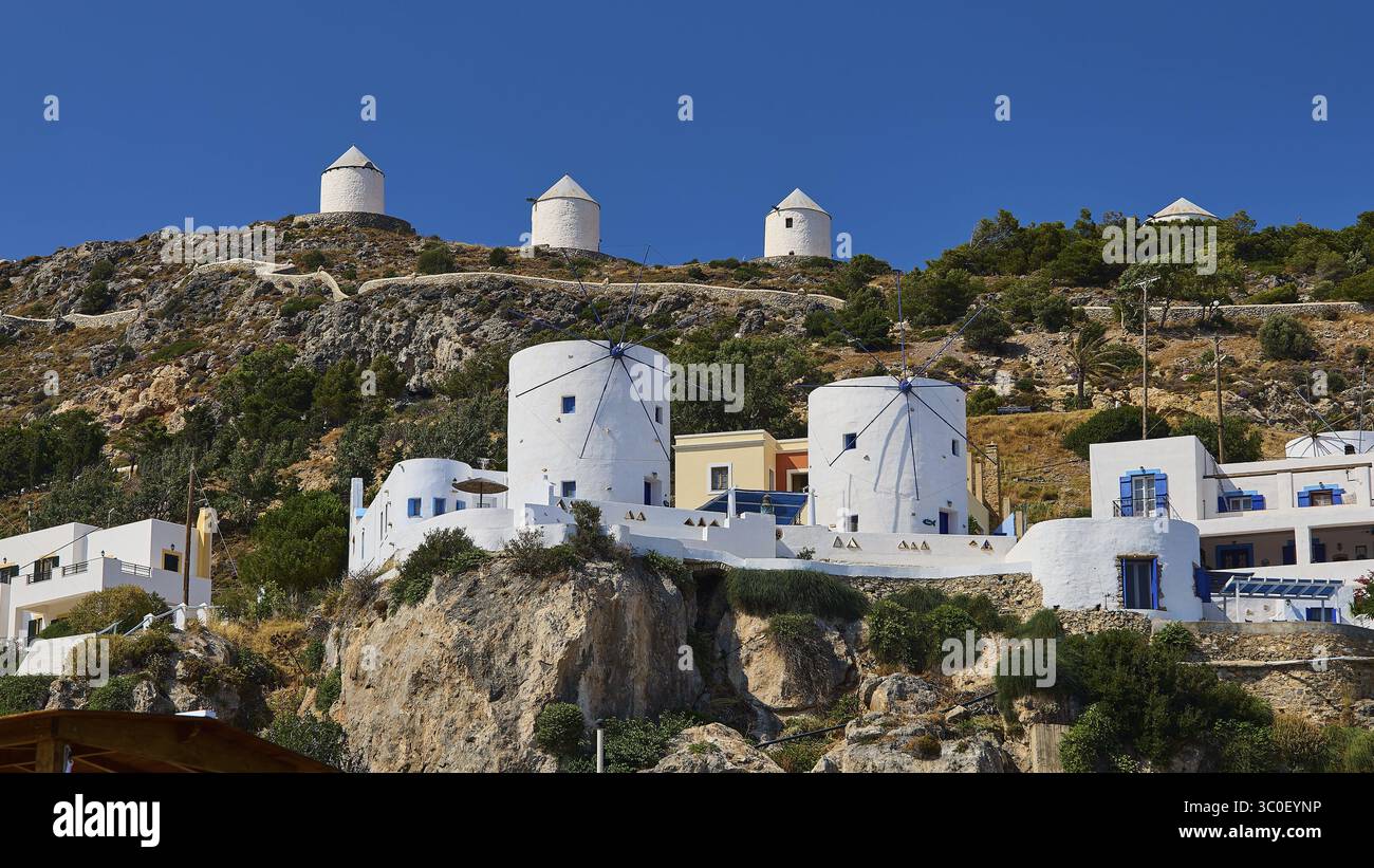 Mulini a vento bianchi ed edifici su un pendio roccioso di un'isola greca, il Castello di Pandeli, il Castello, la Fortezza di Leros, la Fortezza di San Giovanni, Apitiki Hill, Pandeli Ba Foto Stock
