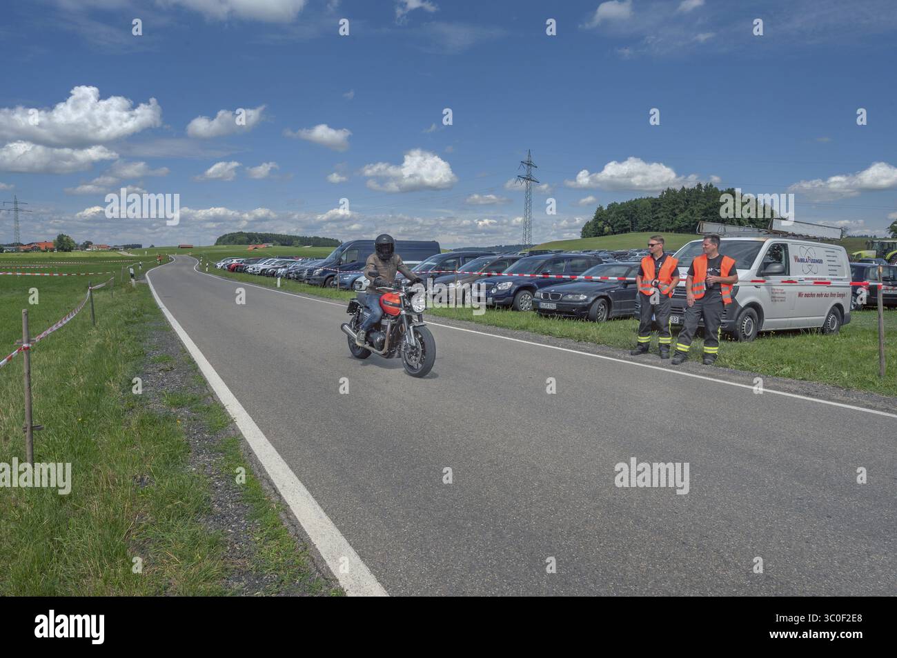 Cumulus, cumulus, cumulus nuvole, su prati estivi con strada di campagna e moto vicino a Reicholzried, Allgaeu, Svevia, Baviera, Germania Foto Stock