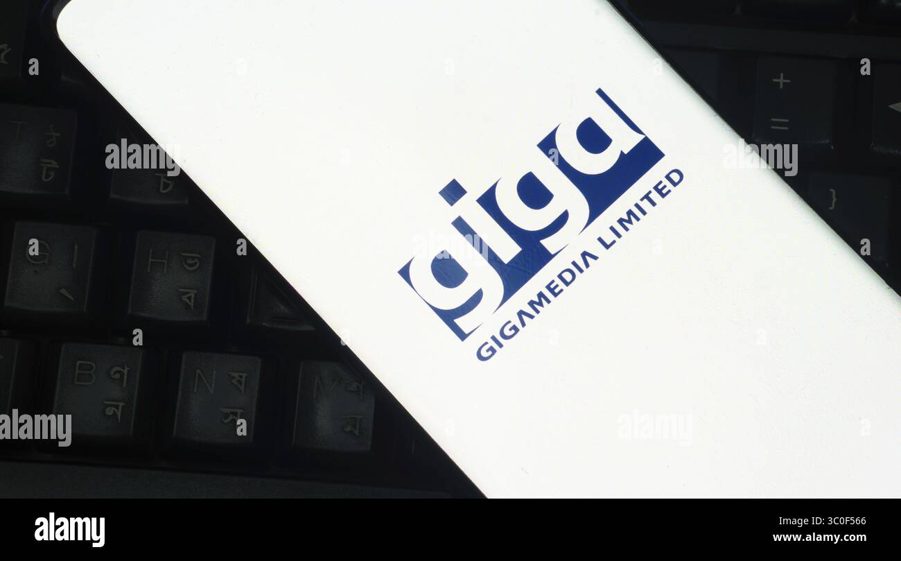 Logo bianco Gigamedia Limited su un telefono posizionato su una tastiera Foto Stock