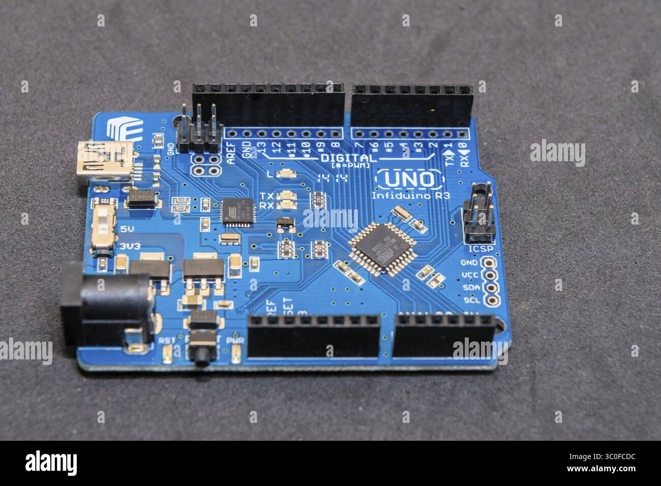 Una scheda Arduino con componenti digitali che presenta un design blu della scheda a circuito stampato Foto Stock