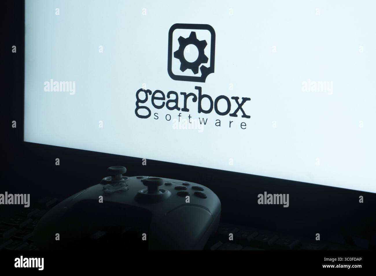 Logo del software Gearbox su uno schermo con la silhouette del controller di gioco Foto Stock