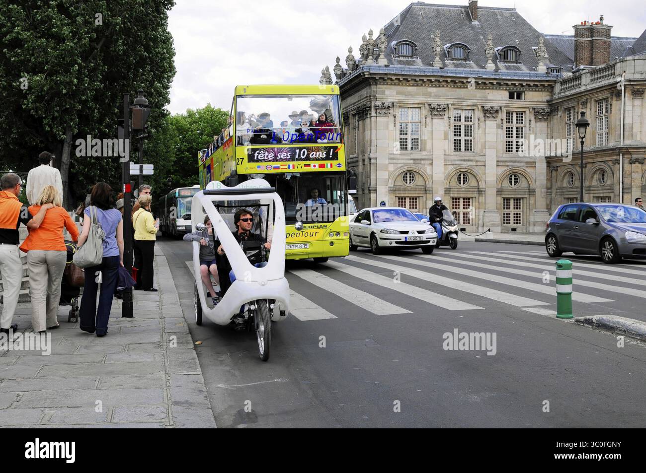 Vivace paesaggio urbano con autobus a due piani, risciò ciclabile e gente di passaggio, Parigi, Francia Foto Stock