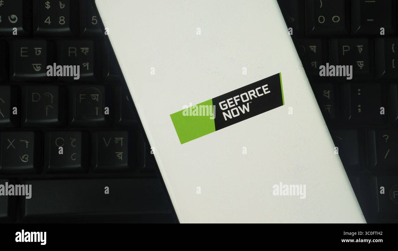 Smartphone con logo "GEFORCE NOW" su sfondo bianco, tastiera nera visibile Foto Stock