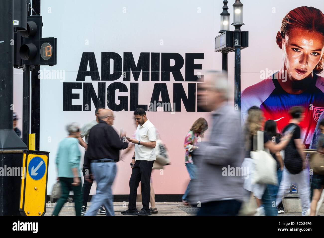Londra, Regno Unito. 21 luglio 2025. Le persone passano davanti agli ormeggi di costruzione fuori Nike Town a Oxford Circus. Il negozio è attualmente in fase di rinnovamento e gli accumuli di costruzione mostrano un messaggio di attualità a sostegno della squadra di calcio femminile inglese, nota come Lionesses, che sta giocando a Euro 2025 in Svizzera. La loro partita successiva è la semifinale contro l'Italia il 22 luglio. Crediti: Stephen Chung / Alamy Live News Foto Stock