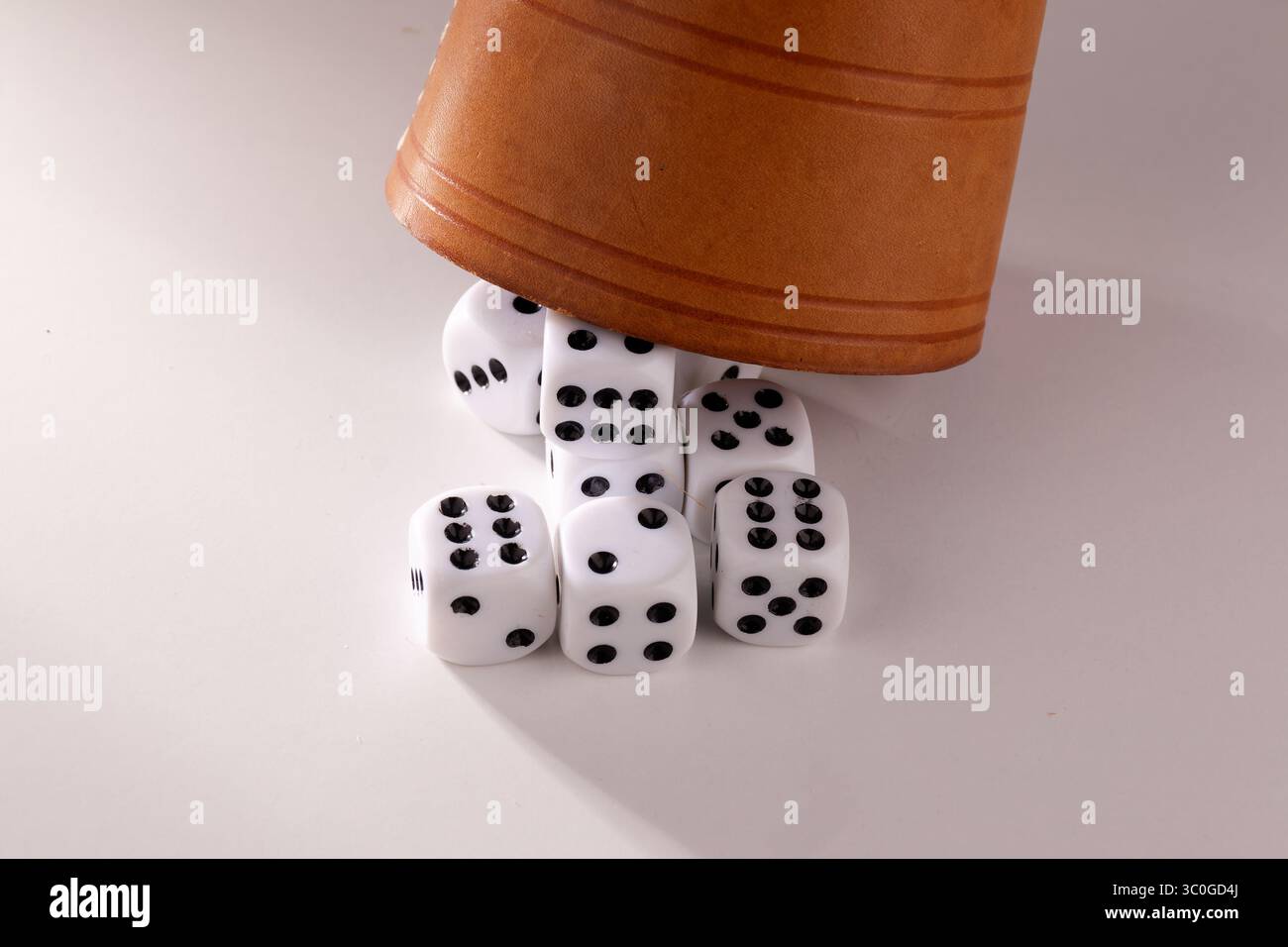 Vista dei dadi posizionati in modo casuale e di una tazza di puzzle dopo un lancio dei dadi Foto Stock