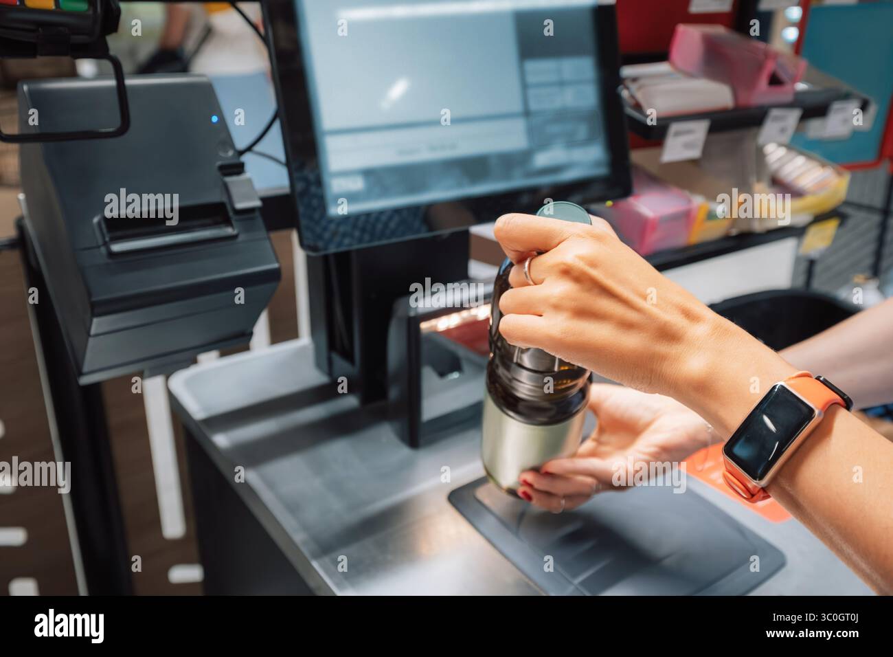 Cassiera femminile che esegue la scansione della spesa al banco cassa del supermercato, utilizzando scanner di codici a barre e computer Foto Stock
