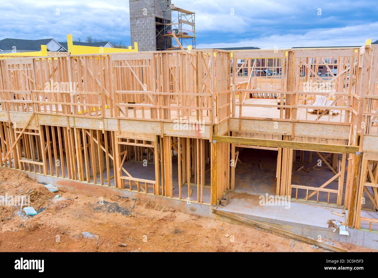I telai in legno si innalzano sul cantiere in un'area residenziale in fase di sviluppo in corso di costruzione in località suburbana. Foto Stock