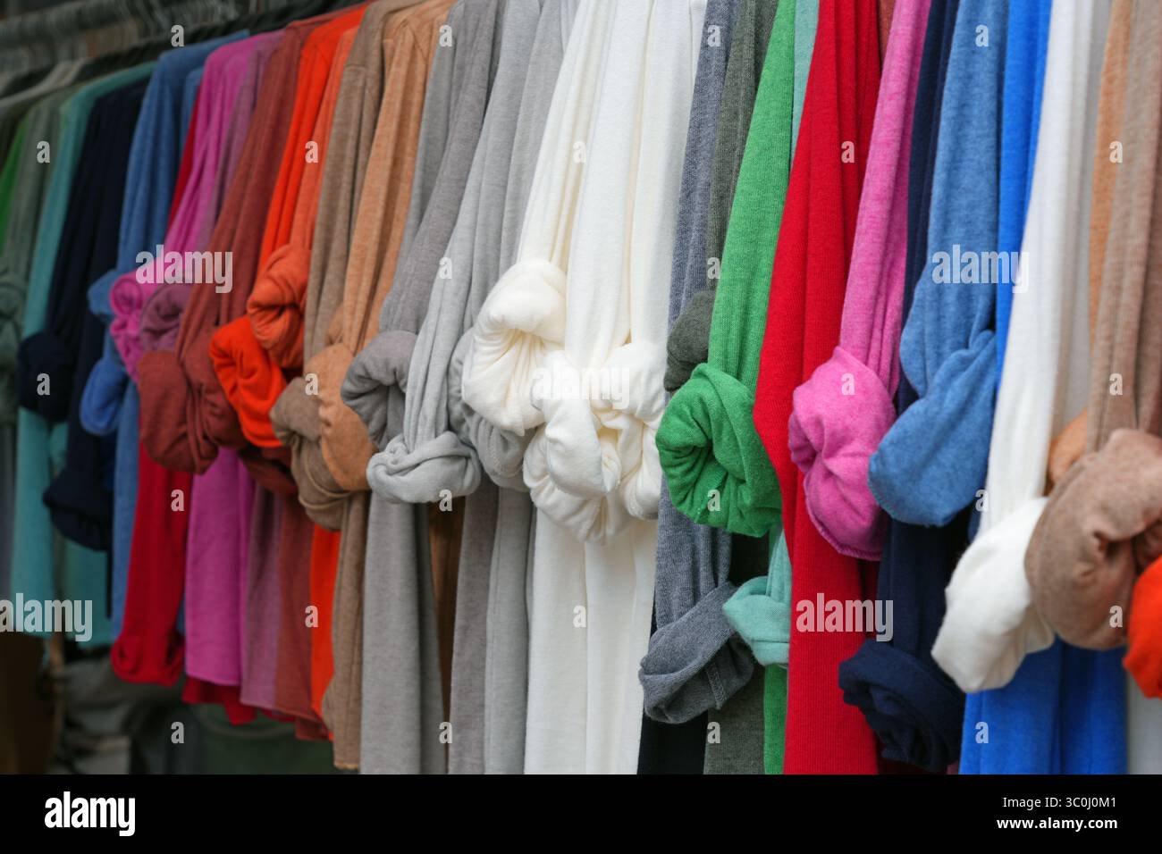 Camicie colorate in lino con maniche arrotolate appese a un rack Foto Stock