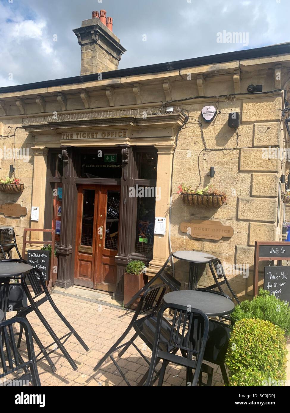 Ilkley Yorkshire stazione ferroviaria binario binario binario binario binario biglietteria cartelli vecchio stile tipo North People walking catch the train chair UK - Immagine stock catturata con smartphone