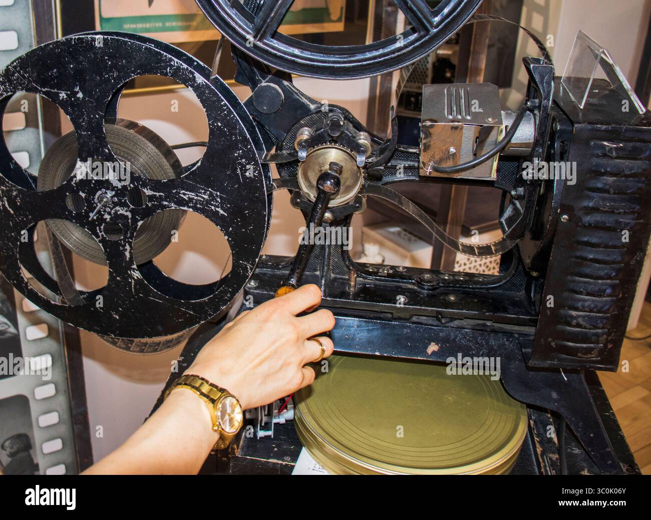 Donna che esamina un proiettore cinematografico d'epoca Foto Stock