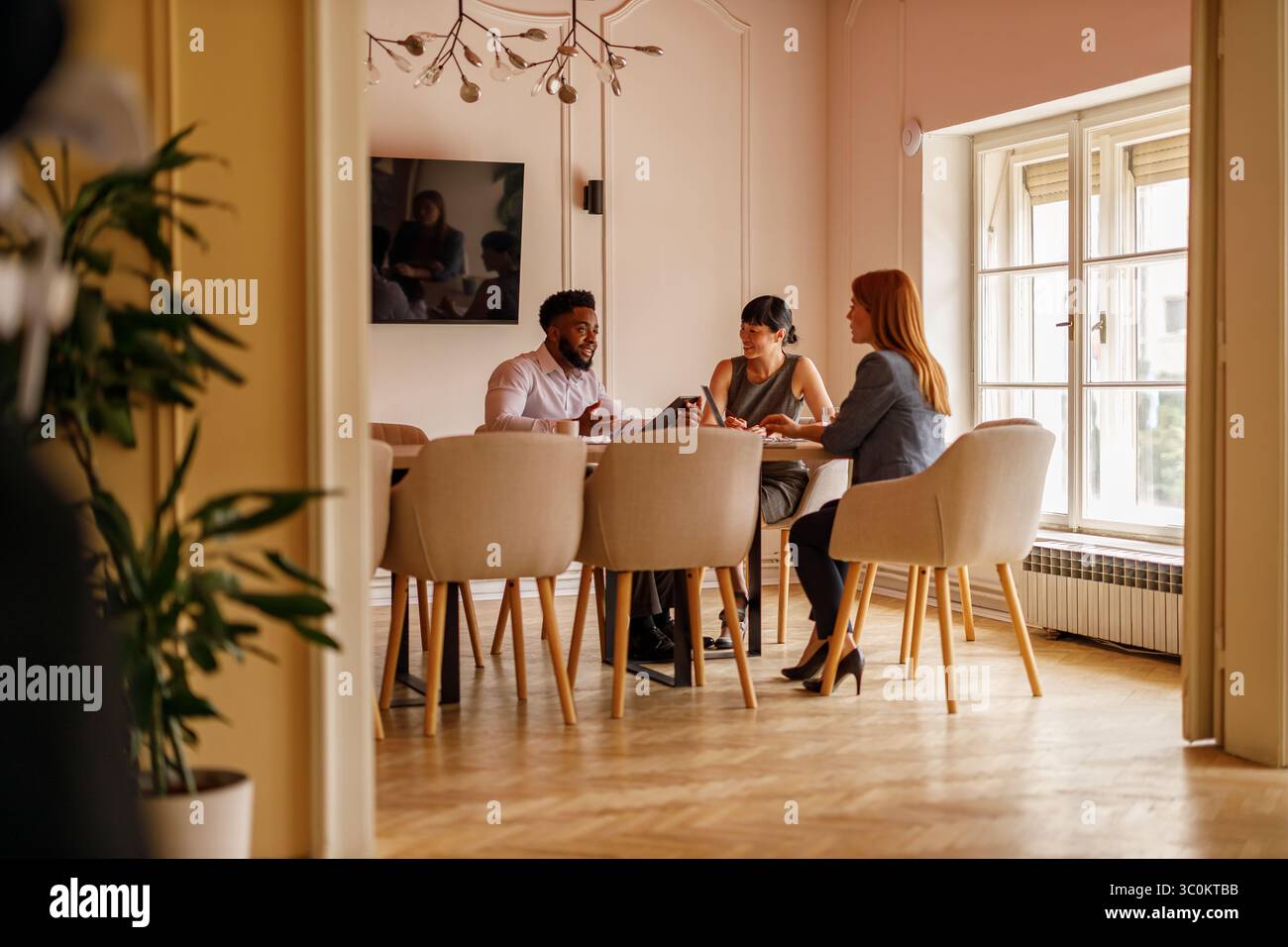 Uomo d'affari che discute e crea brainstorming sulle strategie per le colleghe durante la collaborazione in sala riunioni Foto Stock