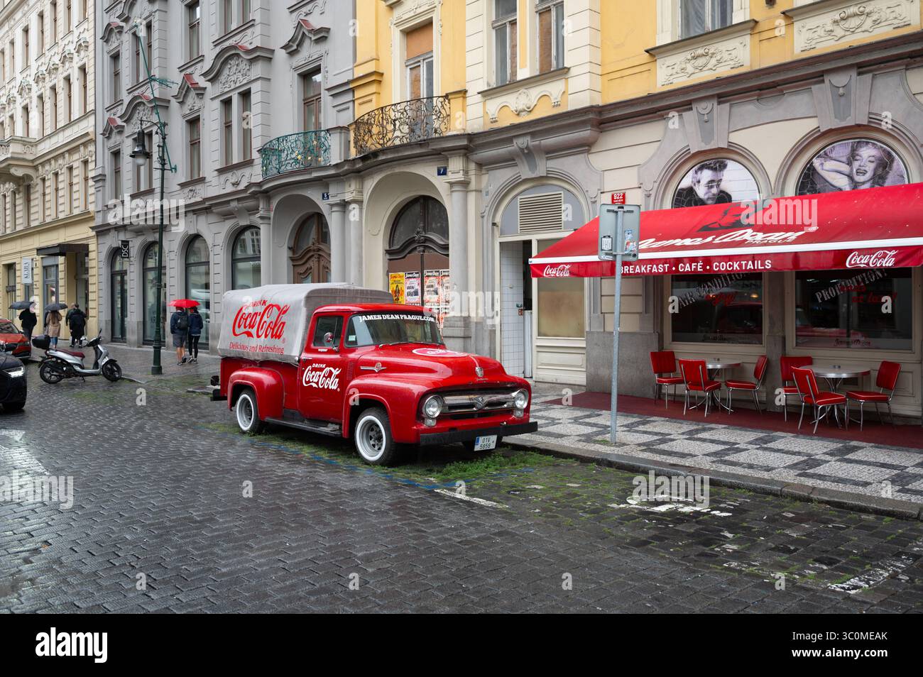 Praga, Repubblica Ceca, 5 agosto 2023. Un furgone rosso brillante Ford F-100 d'epoca con una pubblicità Coca-Cola per le strade del centro storico. Fotogra di strada Foto Stock