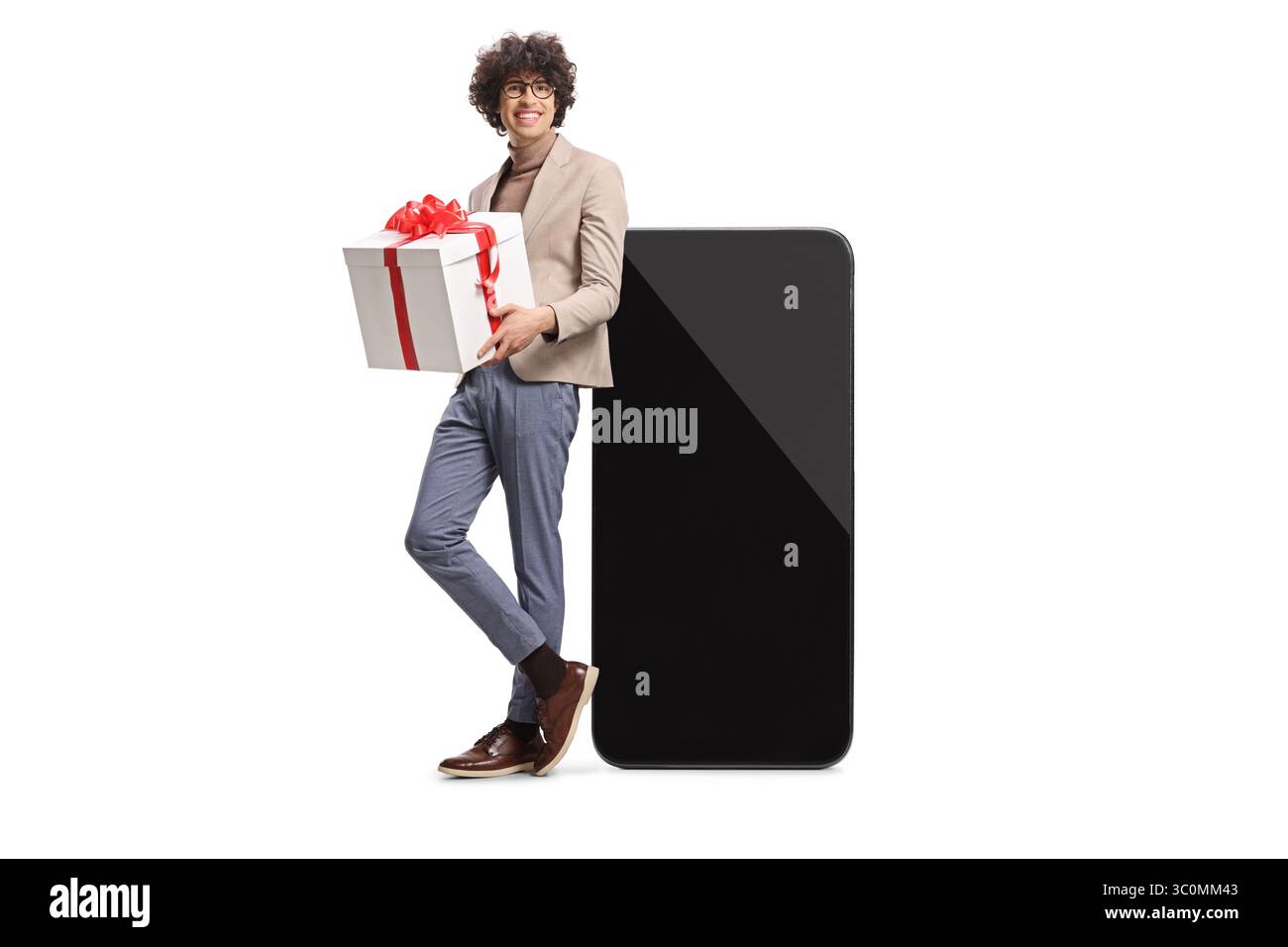 Uomo con una confezione regalo appoggiato su uno smartphone isolato su sfondo bianco Foto Stock