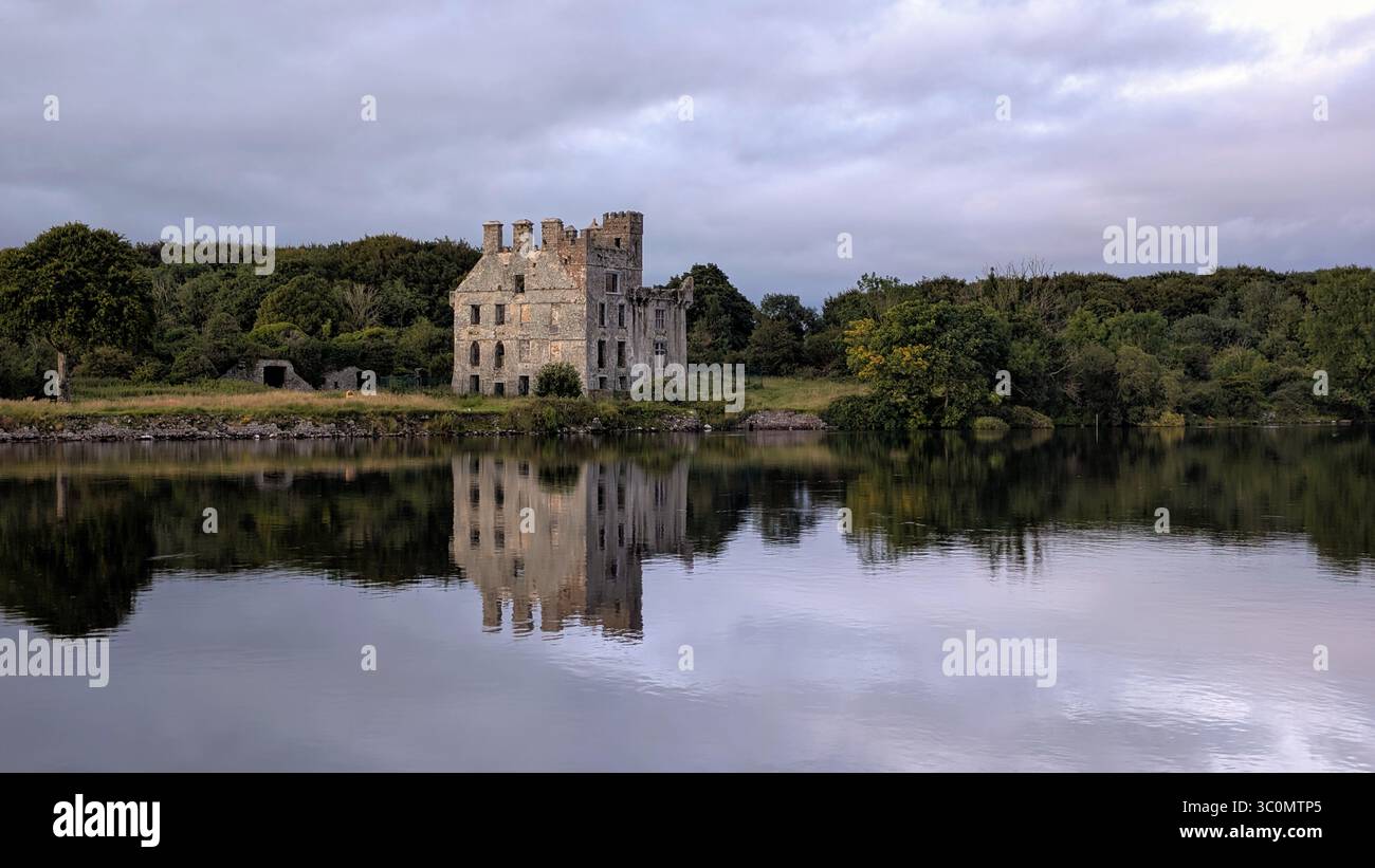 Vista panoramica del tranquillo sito storico del castello di Menlo sul fiume Corrib, la tranquilla riflessione sull'acqua a Galway, Irlanda, con edifici e architettura Foto Stock