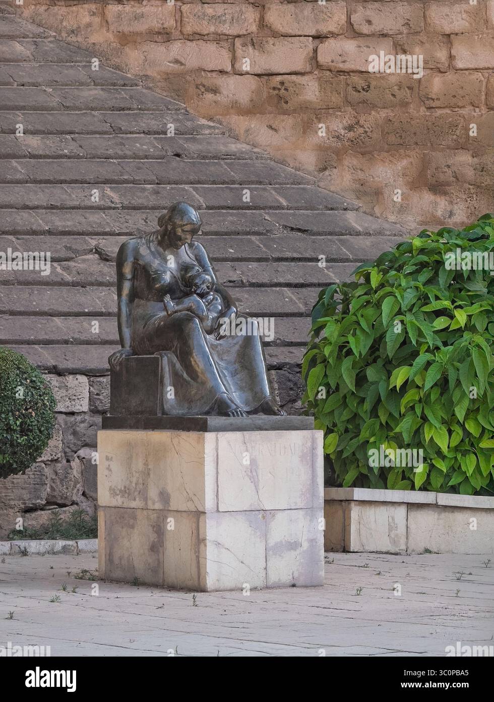 Palma di Maiorca, Spagna - 12 luglio 2024: Statua di madre e bambino di fronte al Palazzo reale di la Almudaina simboleggia l'amore e la cura materna Foto Stock