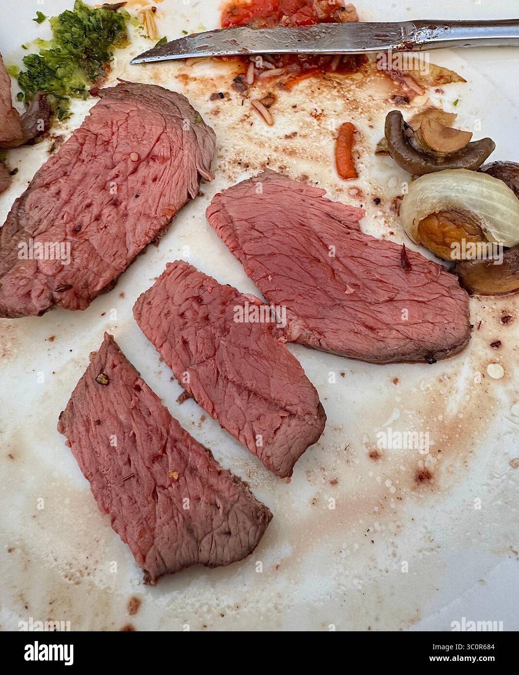 Carne alla griglia a fette servita su un piatto, tipico della cucina brasiliana al barbecue in stile rodizio, accompagnata da funghi e salsa. Foto Stock