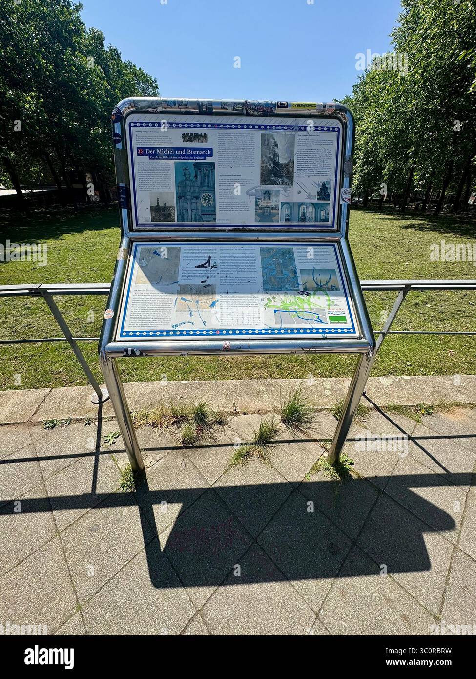 Cartellone informativo all'aperto in un parco di Amburgo, in Germania, con il sole limpido e i lussureggianti alberi verdi sullo sfondo. - Immagine stock catturata con smartphone