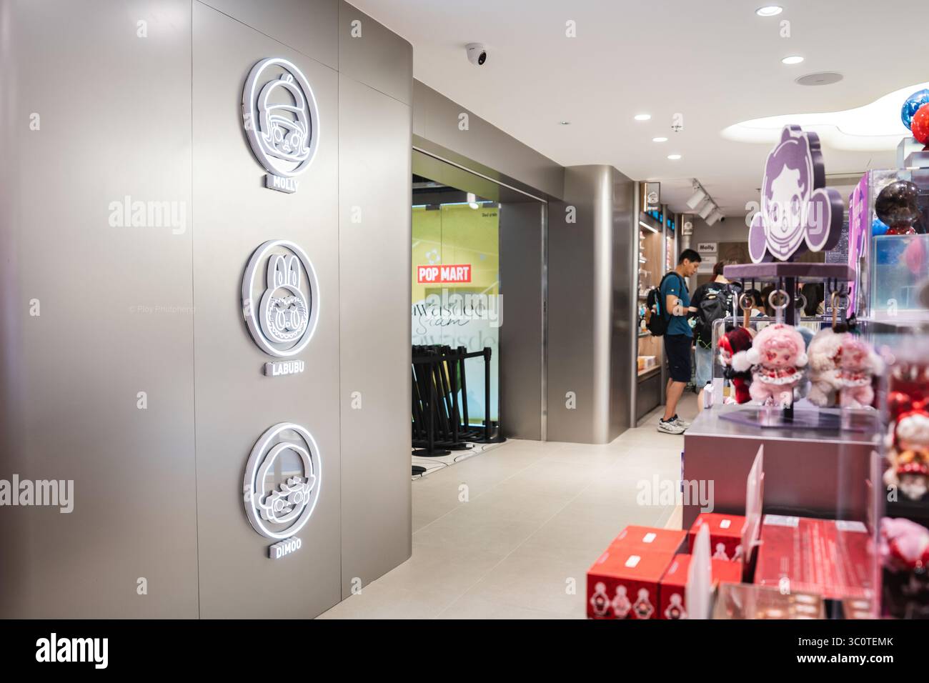 Un'esposizione a parete all'ingresso del Pop Mart Siam Center presenta le icone dei personaggi più amate del marchio, Molly, Labubu e Dimoo, che accolgono i visitatori in un vivace mondo di giocattoli da collezione. I collezionisti di scatole cieche di POP Mart hanno scatenato una mania culturale in tutta l'Asia e oltre, con i fan che inseguono figure rare come Labubu e Molly. Lanciato nel 2016 con le bambole Molly dall'artista di Hong Kong Kenny Wong, il marchio ha riscosso un enorme successo grazie alle vendite guidate dalla suspense. Attualmente presente in oltre 30 paesi e raggiungendo quasi 100 attraverso pop-up e partnership, Pop Mart è diventato un giocattolo di design Foto Stock