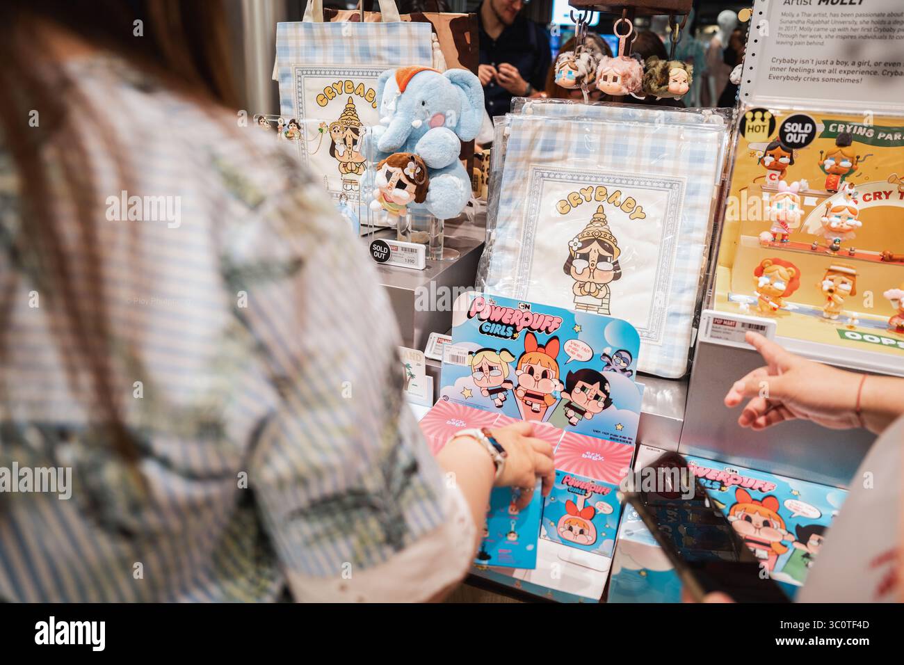 Gli acquirenti curiosano tra i collezionisti crossover Crybaby e Powerpuff Girls al Pop Mart. L'artista tailandese dietro Crybaby reinventa i personaggi iconici dei cartoni animati attraverso una lente nostalgica ed emotiva, che fonde la cultura pop con la narrazione personale. I collezionisti di scatole cieche di POP Mart hanno scatenato una mania culturale in tutta l'Asia e oltre, con i fan che inseguono figure rare come Labubu e Molly. Lanciato nel 2016 con le bambole Molly dall'artista di Hong Kong Kenny Wong, il marchio ha riscosso un enorme successo grazie alle vendite guidate dalla suspense. Oggi opera in oltre 30 paesi, raggiungendo quasi 100 attraverso pop-up e partne Foto Stock