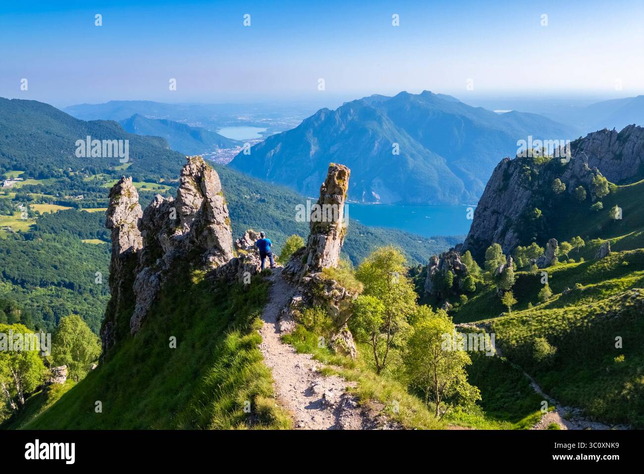 Veduta aerea di un uomo che cammina tra i pinnacoli di roccia sul lato del Colle Pertusio vicino al Rifugio Rosalba. Piani Resinelli, Lecco, Lombardia, Italia. Foto Stock