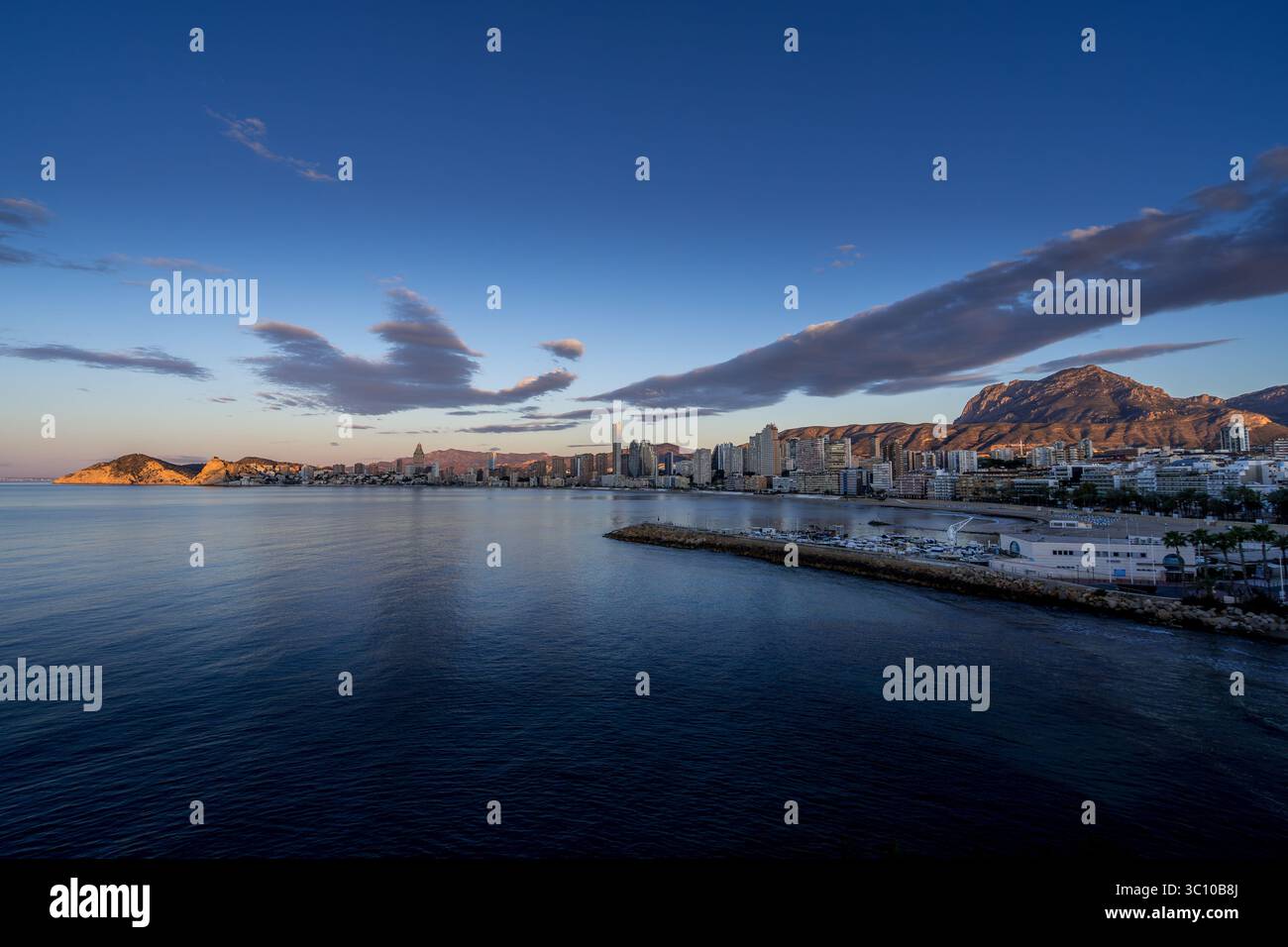 La luce del sole di mattina presto illumina il fronte spiaggia di Benidorm Foto Stock