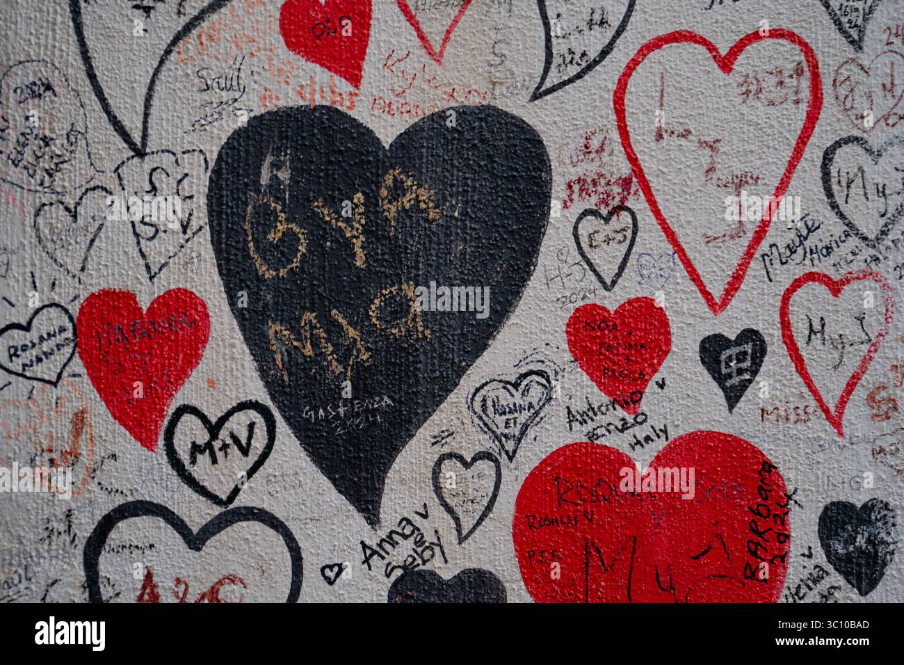 Parete ricoperta di graffiti cuori d'amore e iniziali degli amanti Foto Stock