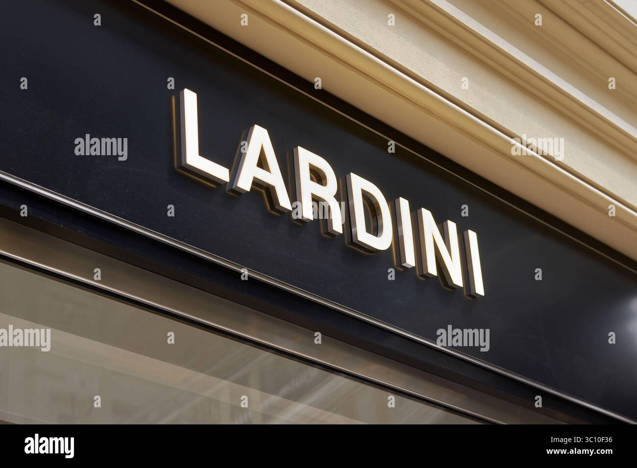Il negozio Lardini illuminato firma sulla facciata nera del centro commerciale di lusso Foto Stock
