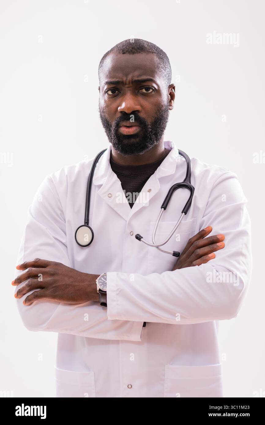 Ritratto di un paramedico maschile nero preoccupato che si sente preoccupato, che pensa e guarda la fotocamera. Studio girato su sfondo grigio. Foto Stock