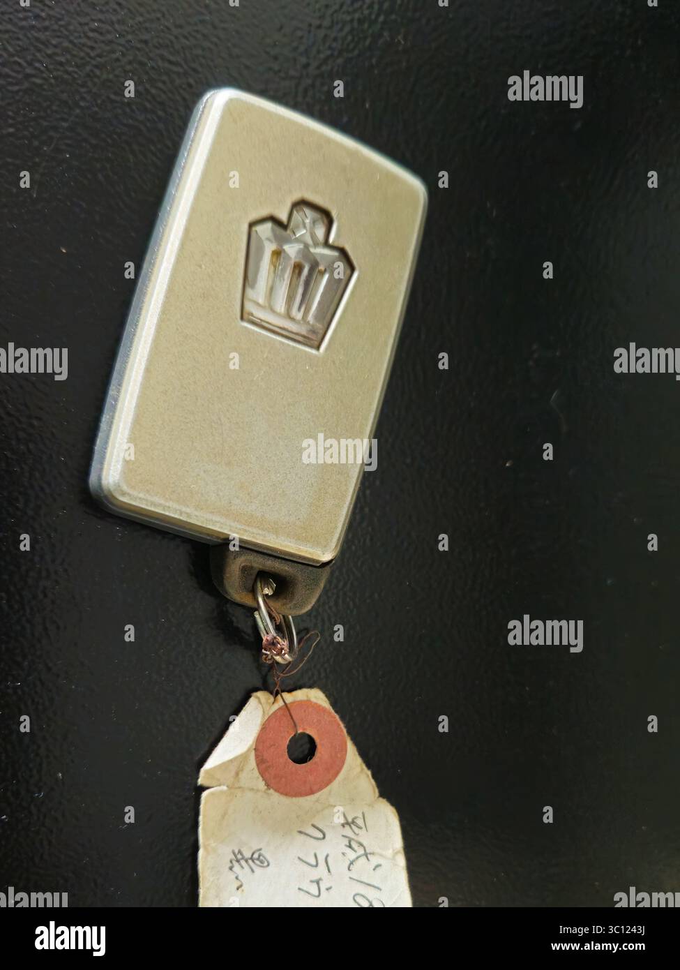 Portachiavi vintage con logo a corona e tag scritto a mano Foto Stock