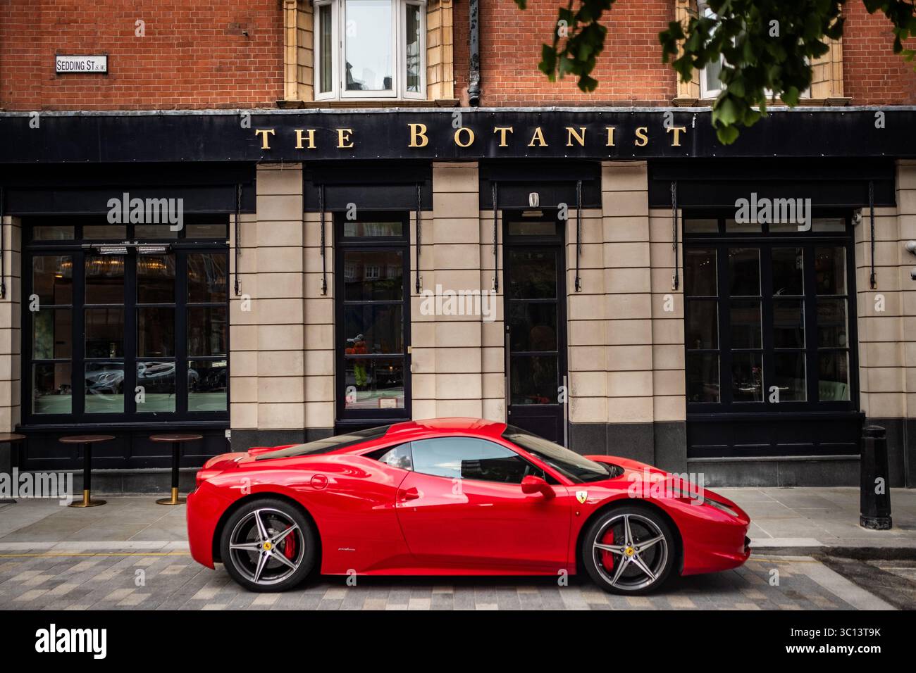 LONDRA - 14 LUGLIO 2025: Il botanico in Sloane Square a Chelsea con Ferrari parcheggiata fuori. Ristorante inglese di lusso Foto Stock