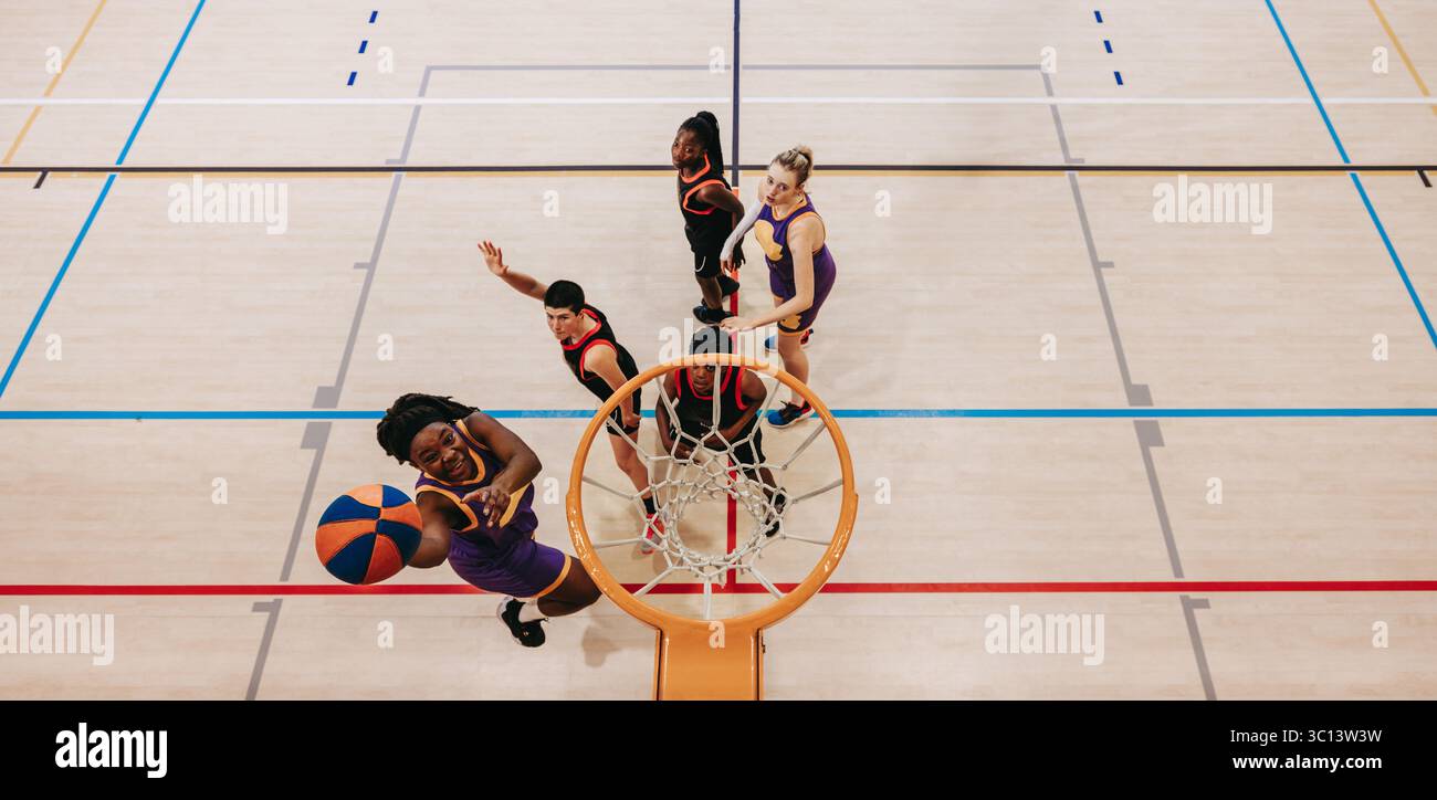 Una vista dall'alto dei giovani atleti in una partita di basket, che mostra le dinamiche dei giocatori e il lavoro di squadra Foto Stock