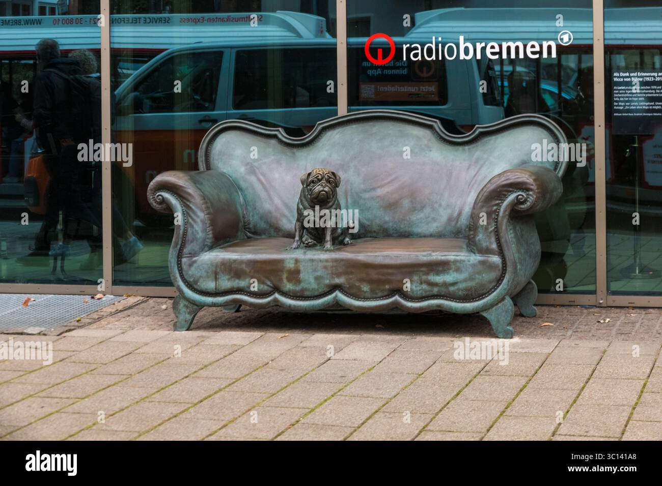 Una scultura in bronzo del divano Loriot, ben nota in Germania dalla serie televisiva Loriot, con un cane che siede su di esso. Commemora il ... Foto Stock