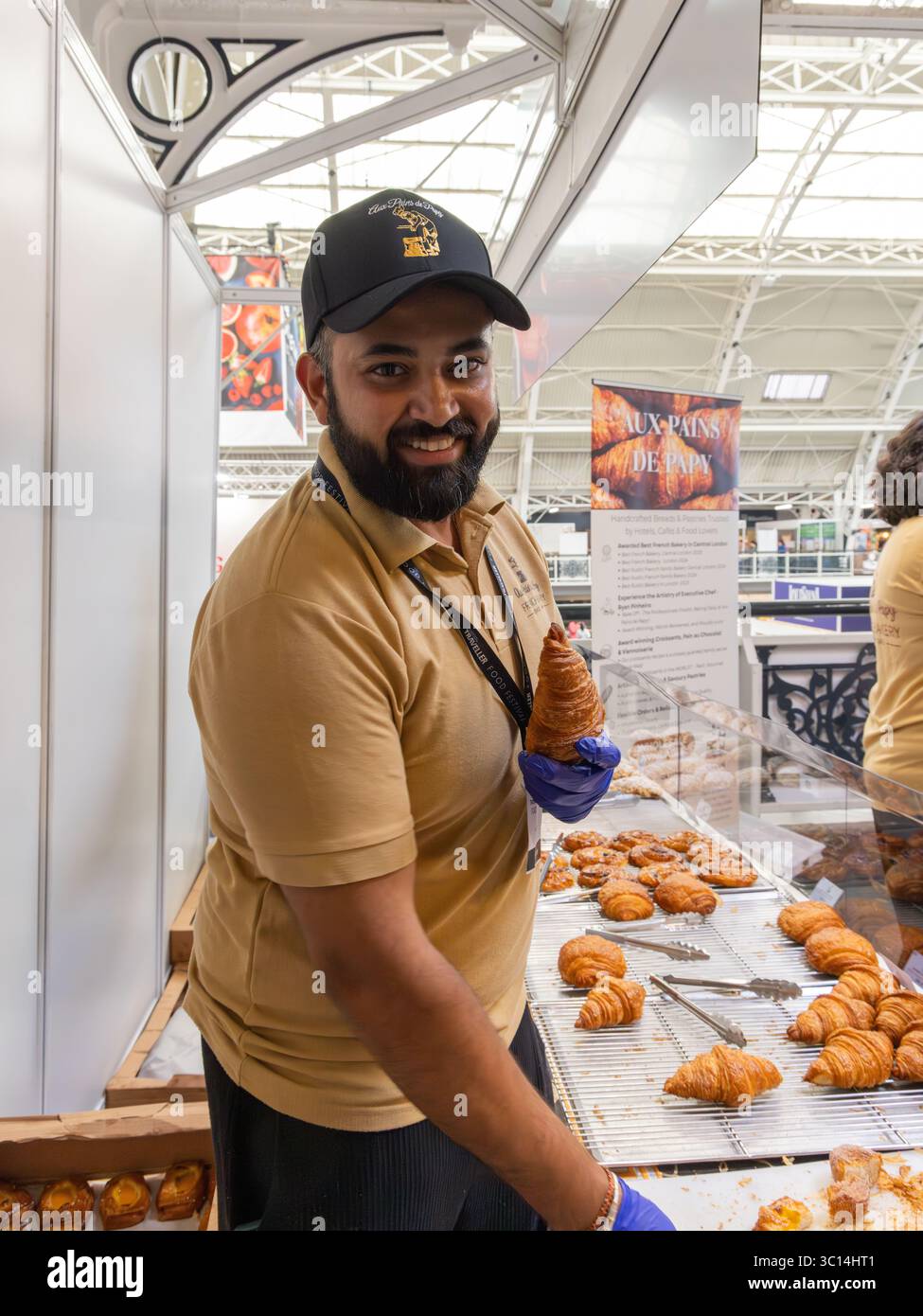 Espositore gastronomico presso lo stand SweetDoughThings, il festival gastronomico National Geographic Traveller che si posa con un caratteristico croissant Foto Stock
